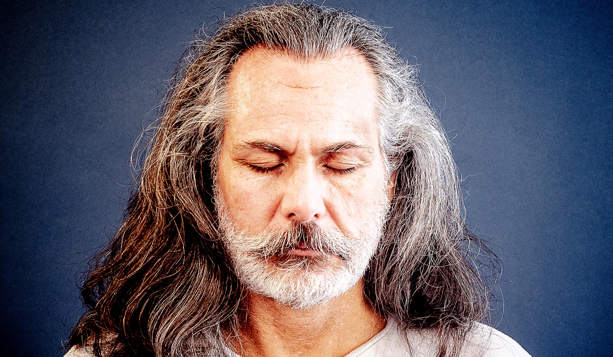 Man with beard meditating to improve concentration.