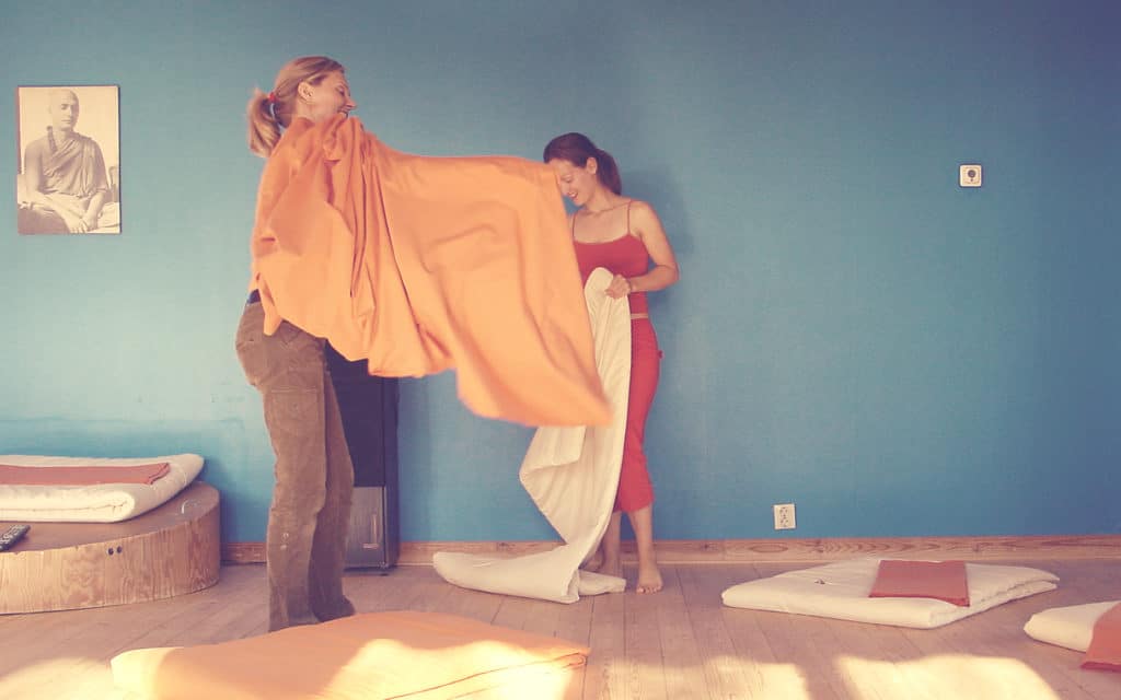 Vigyana Shakti and Padma Shakti changing yoga mat covers at Haa course center.