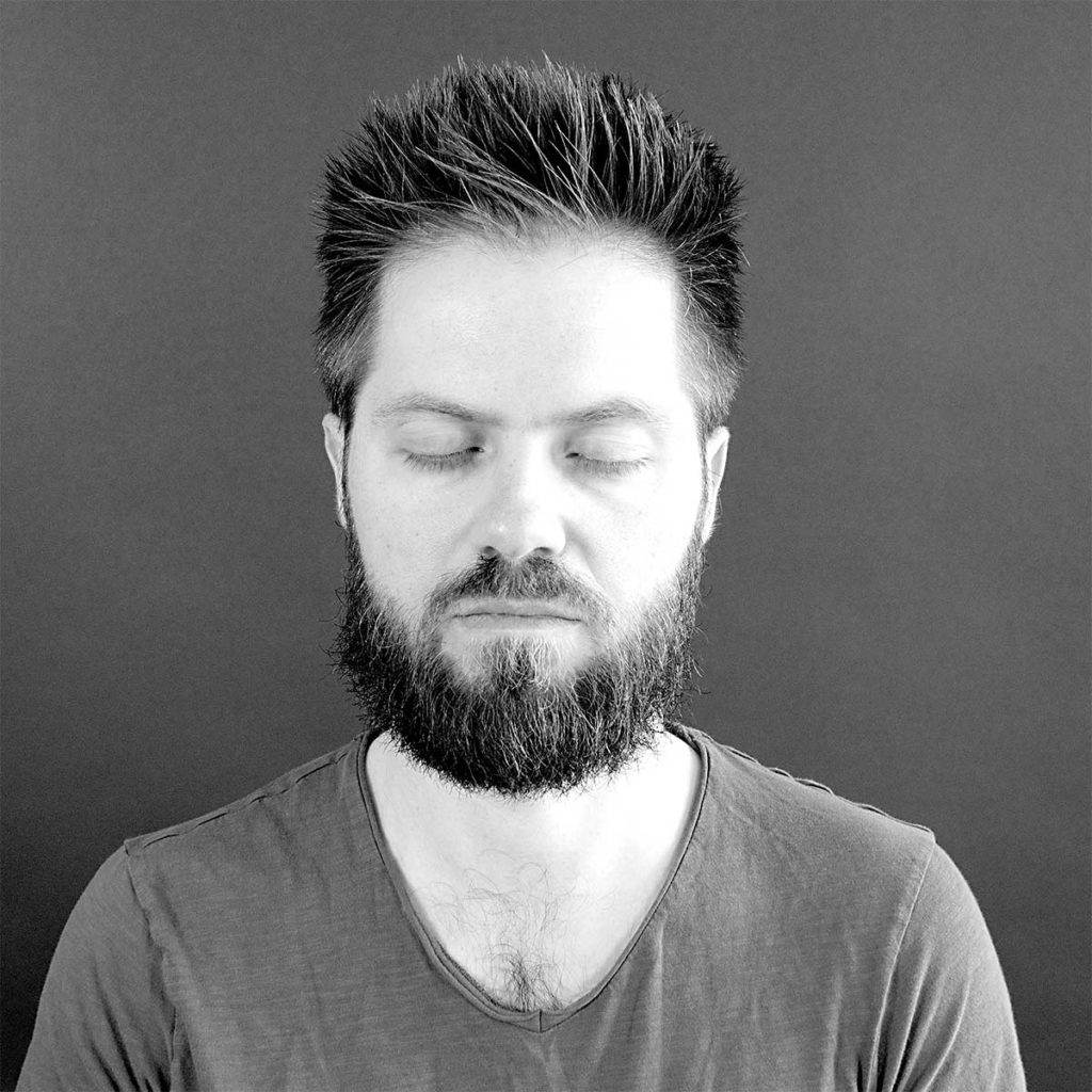 Young man with beard meditating.