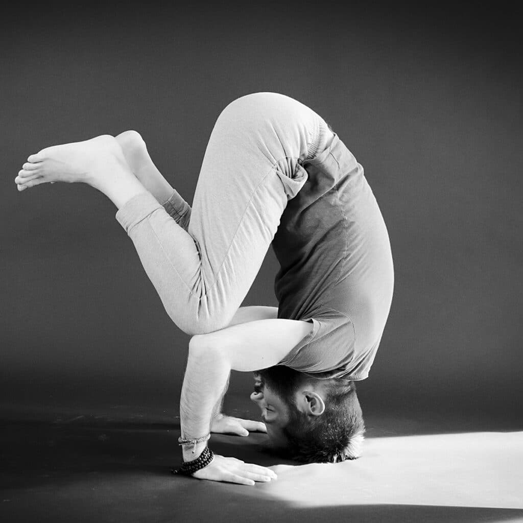 A man in the clown pose, the easy alternative to headstand.