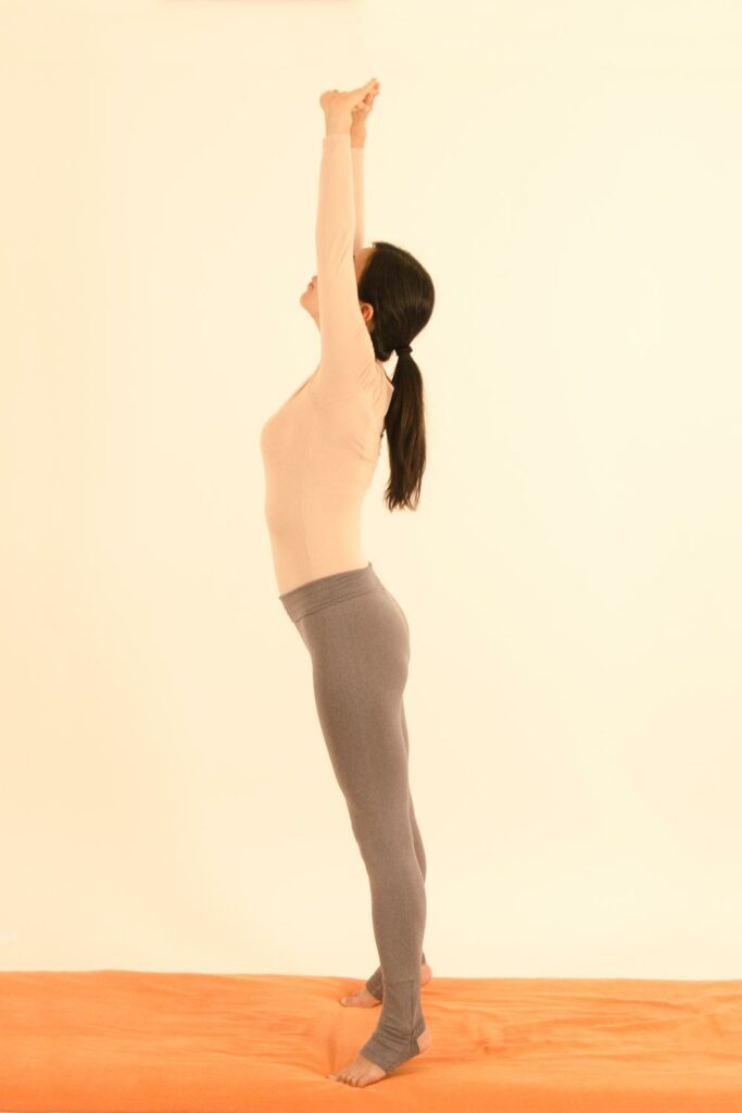 Young woman doing the stretching palm pose.