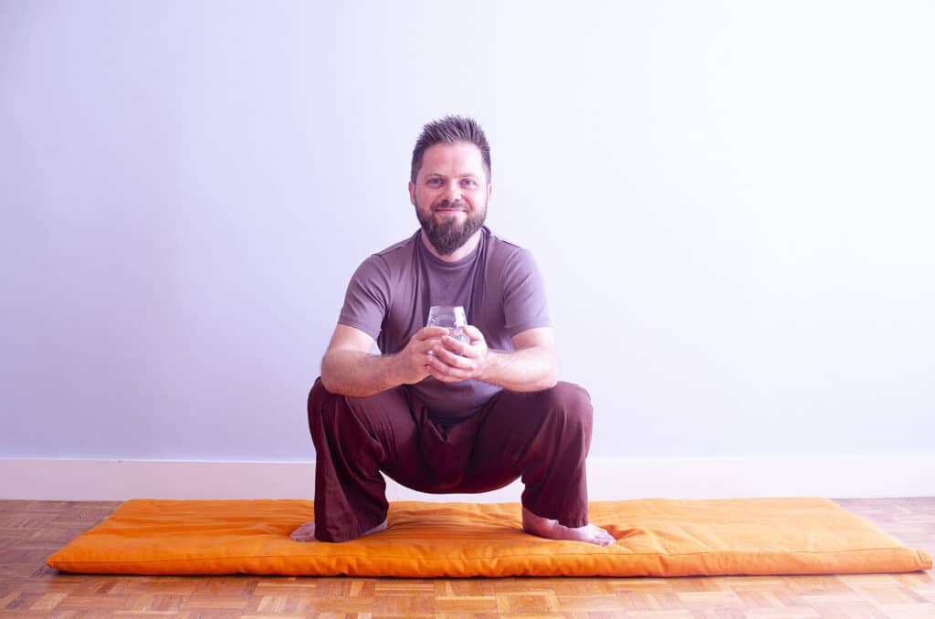 Man sitting in the squatting pose during shankhaprakshalana.